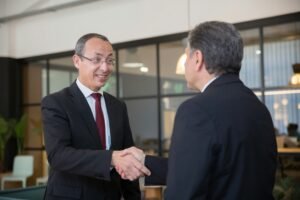 Two businessmen in suits shaking hands, symbolizing a successful business deal.